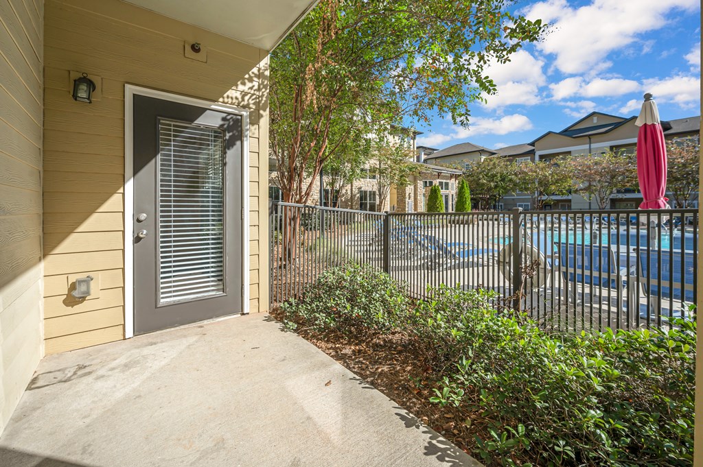 A view of a house entrance with a pool in the background.